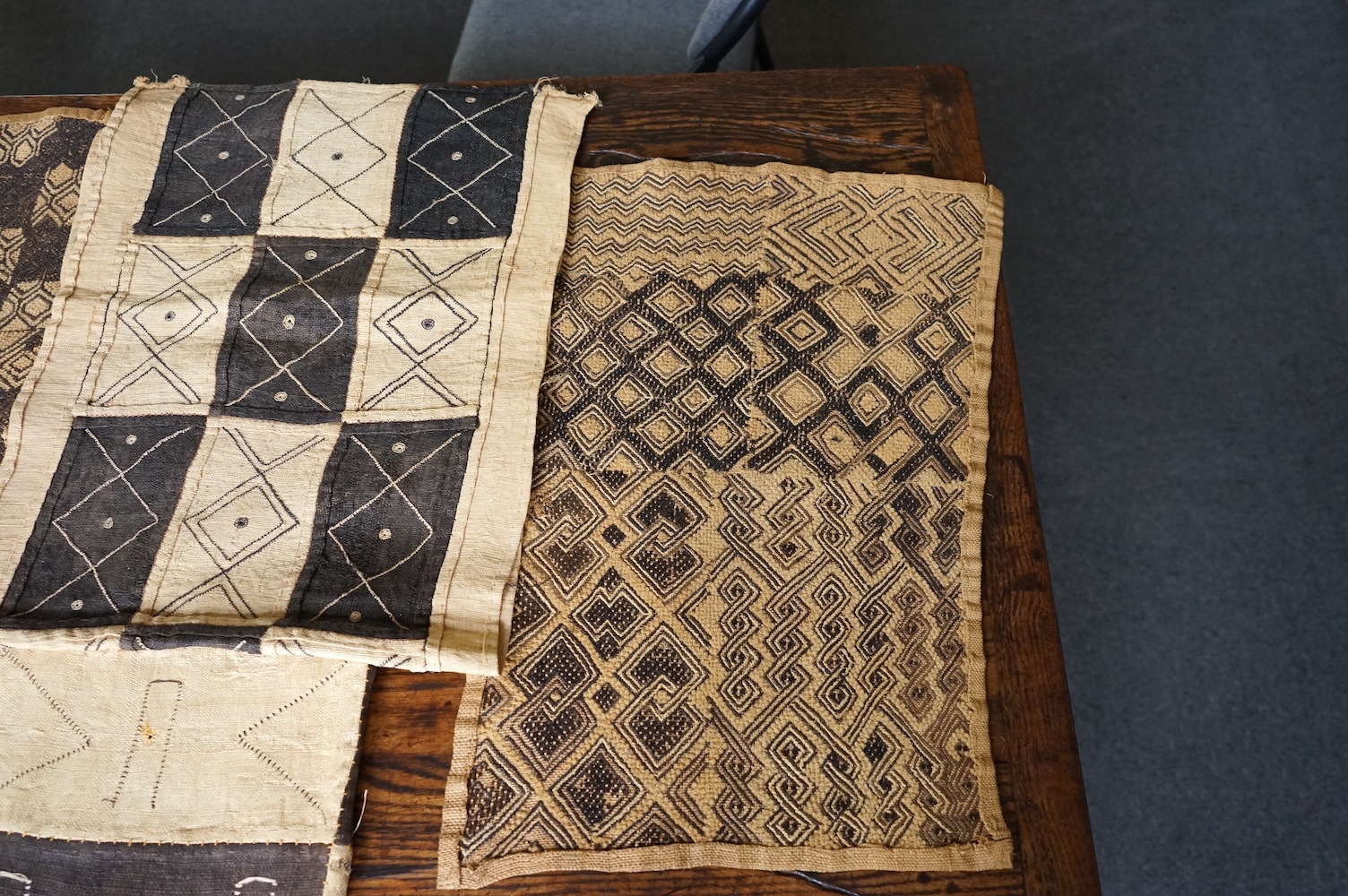 A collection of five 20th century African Congo hand woven and embroidered raffia palm leaf runners and mats, together with a later large printed hanging. 260cm x 138cm. Condition - one smaller mat has a hole in the weav